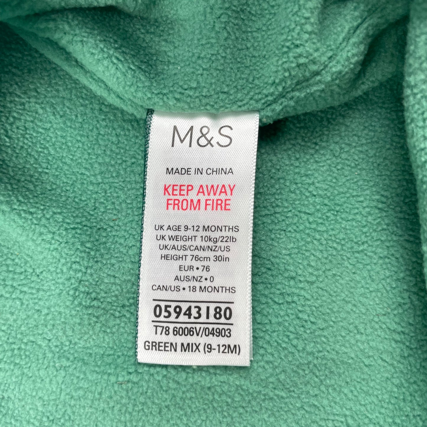 Grüner Regenanzug mit Kapuze und Tropfenmuster für Babys. – label