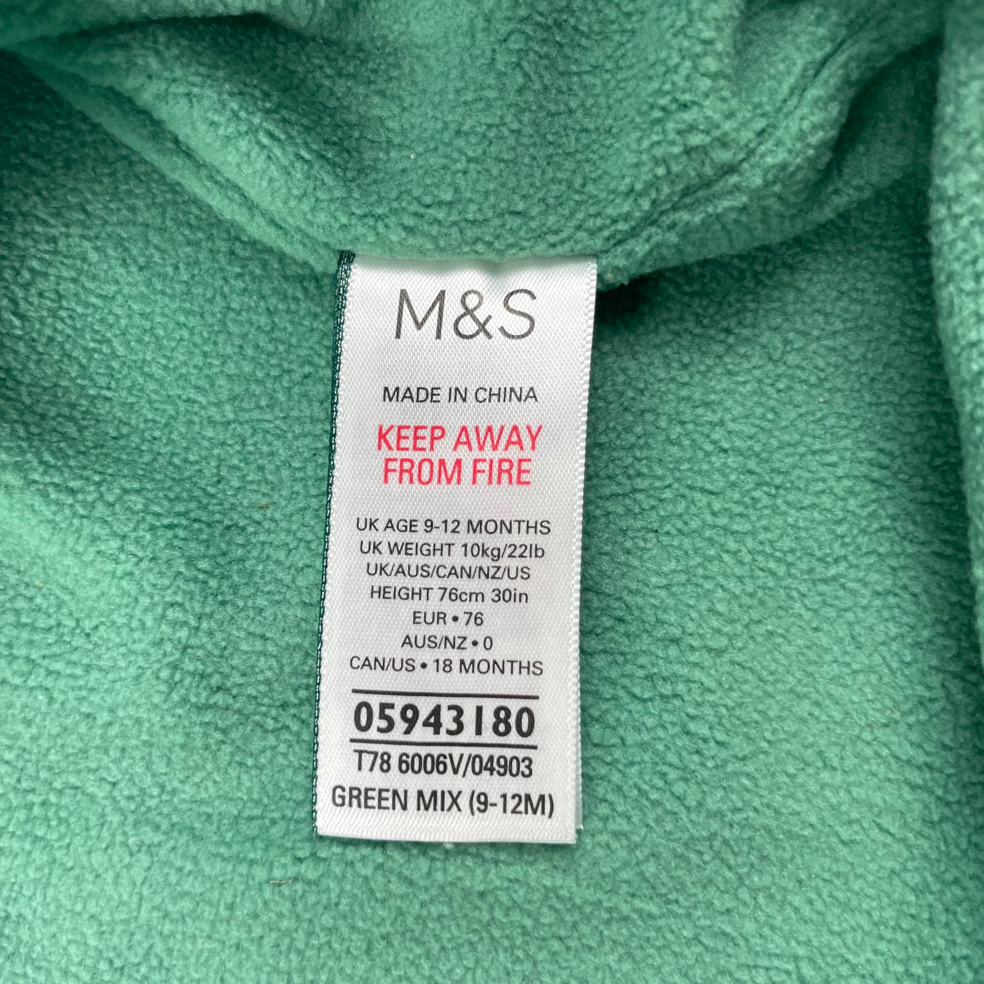 Grüner Regenanzug mit Kapuze und Tropfenmuster für Babys. – label