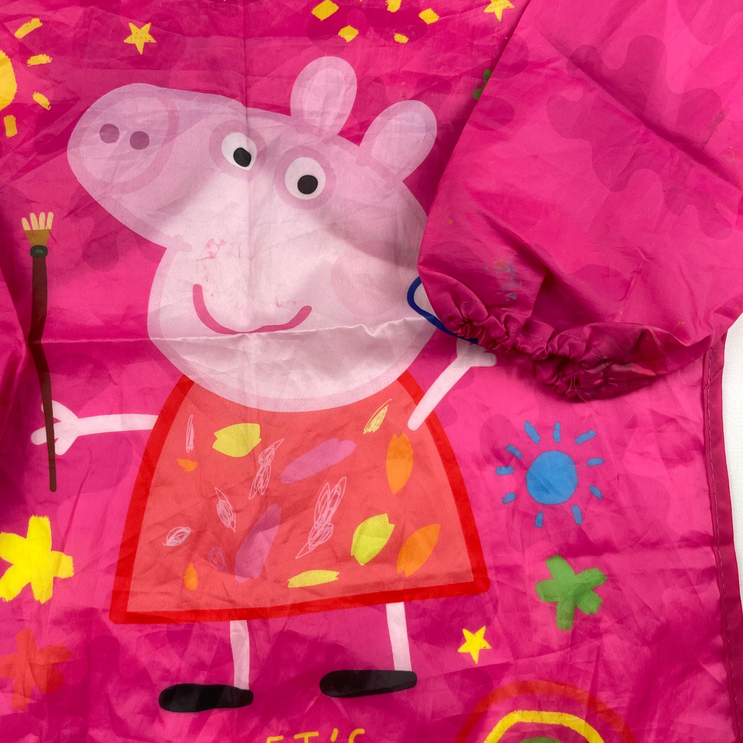Rosa Malkittel mit Peppa Pig Motiv und "Let's Make Stuff" Aufdruck. – detail